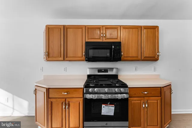 a kitchen with stainless steel appliances granite countertop a stove a microwave and cabinets