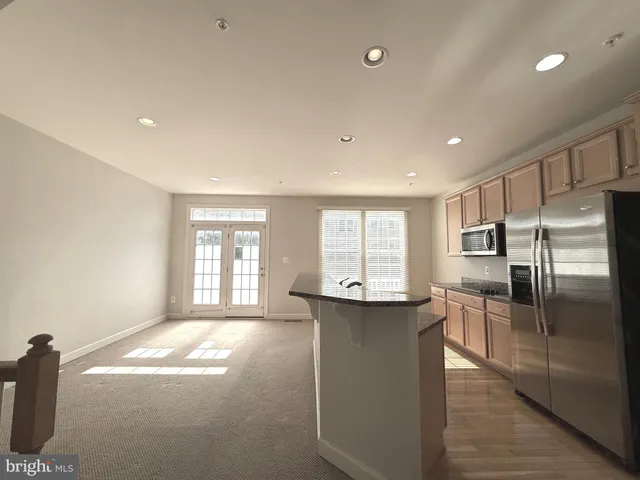 a kitchen with stainless steel appliances granite countertop a refrigerator a sink a stove and oven