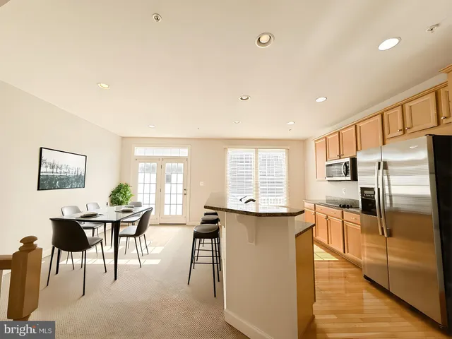 a kitchen with stainless steel appliances kitchen island granite countertop a sink and cabinets