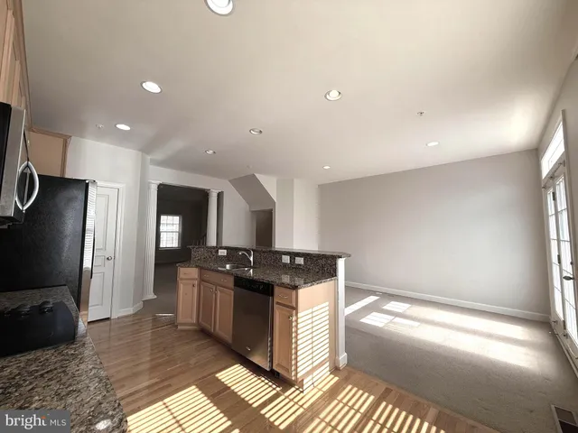 a kitchen with stainless steel appliances granite countertop a stove a sink and a refrigerator