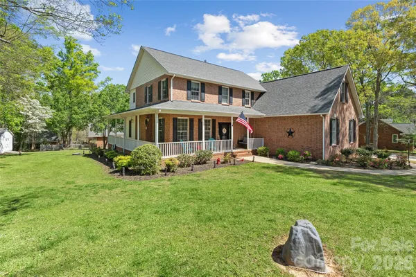 a front view of a house with a yard and trees