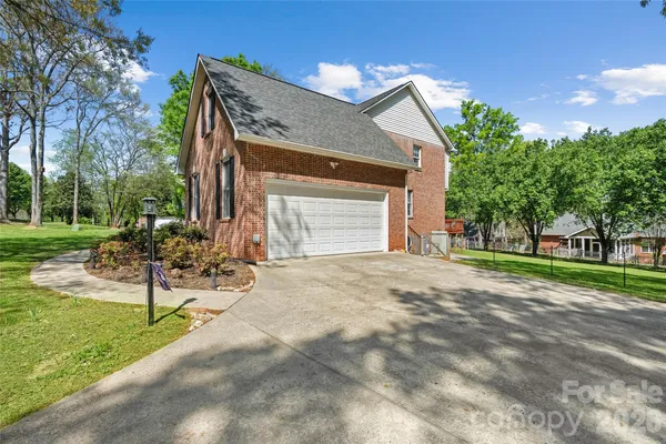 a view of a house with backyard and a tree