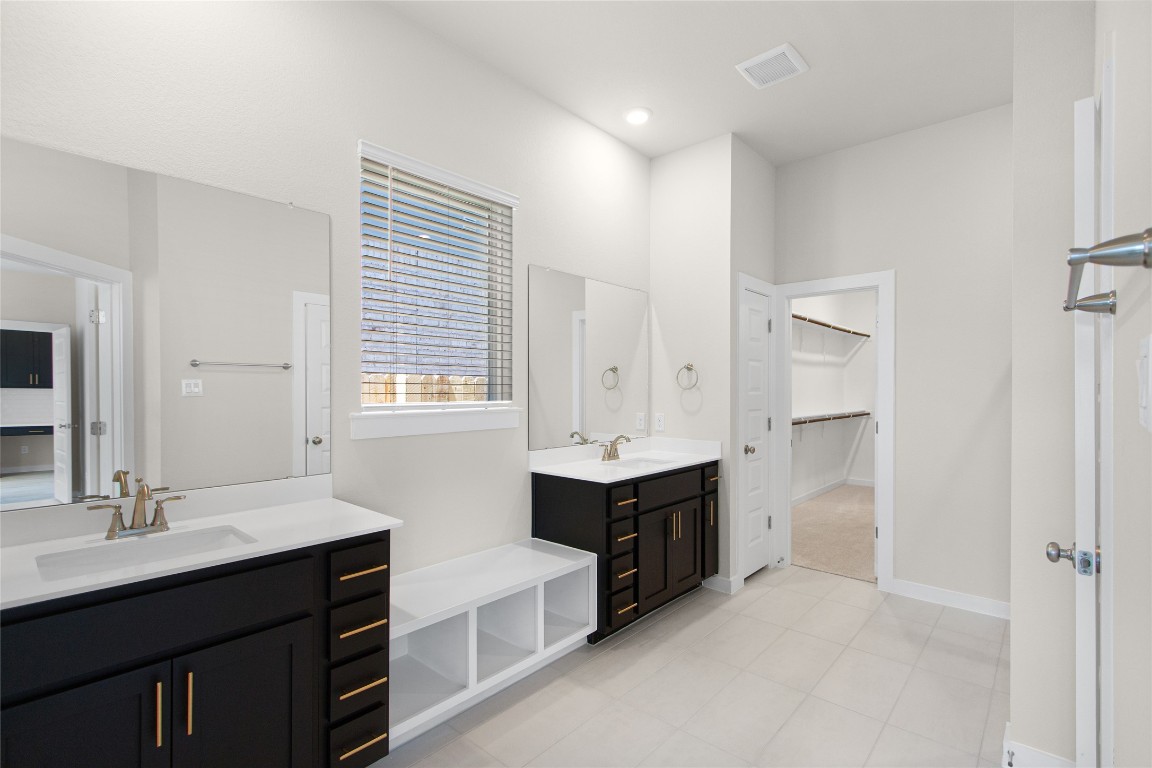 405 Raleigh Drive Georgetown, TX 78633 - Photo 28 of 36 a spacious bathroom with a double vanity sink a bathtub and a mirror