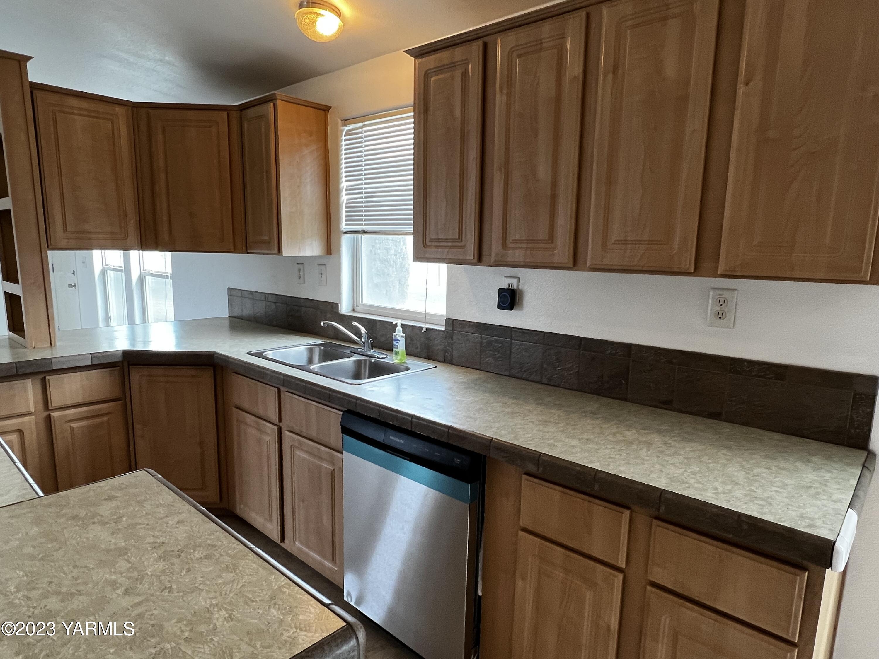 12102 North Hinzerling Road Prosser, WA 99350 - Photo 20 of 43 a kitchen with stainless steel appliances granite countertop wooden cabinets a sink and dishwasher