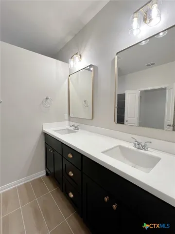 a bathroom with a double vanity sink and mirror