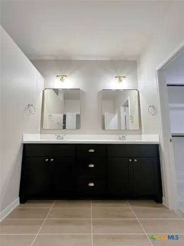 a bathroom with a double vanity sink and a mirror