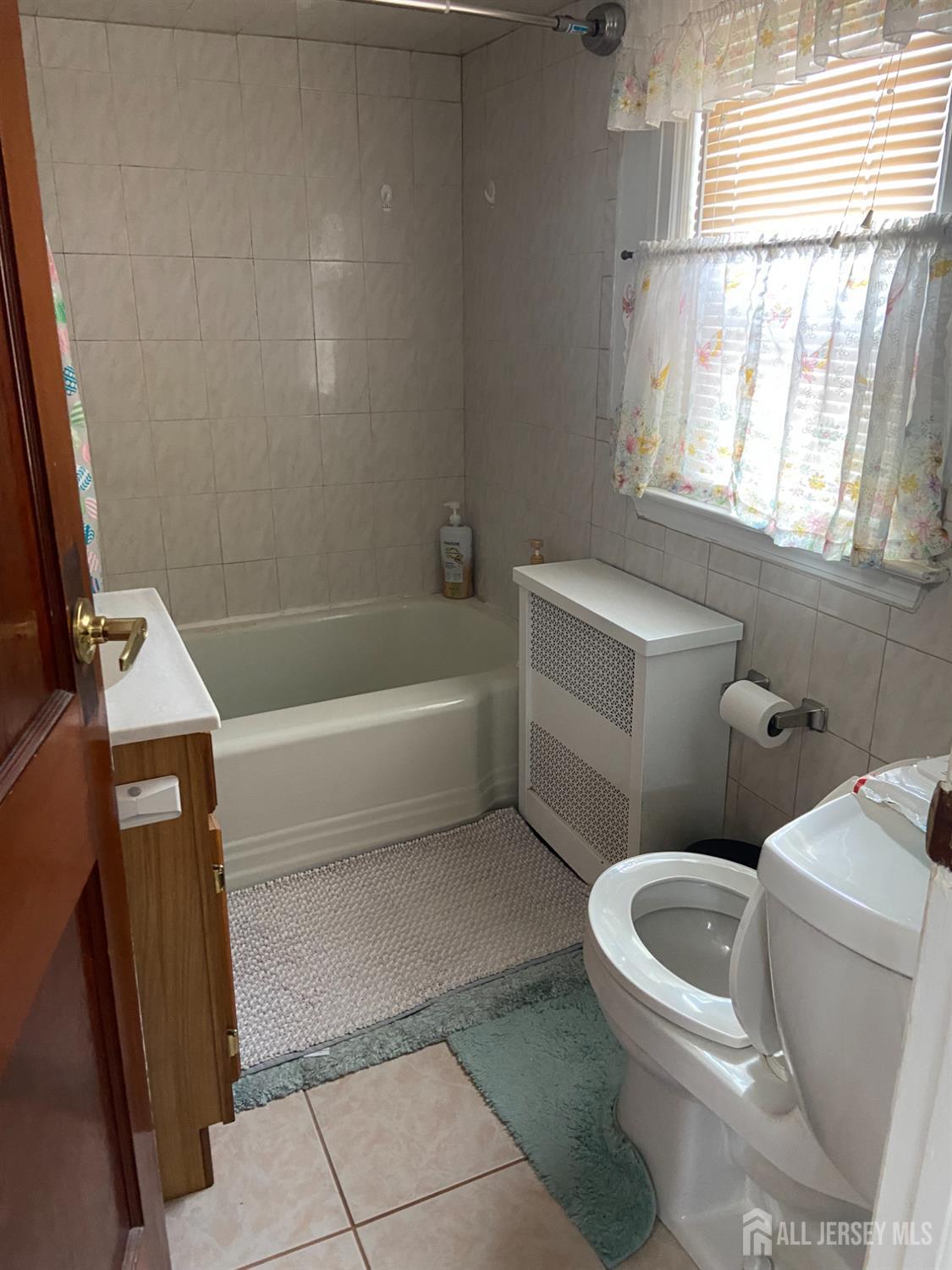 739 Ridgedale Avenue Woodbridge, NJ 07095 - Photo 8 of 10 a white toilet sitting next to a bath tub