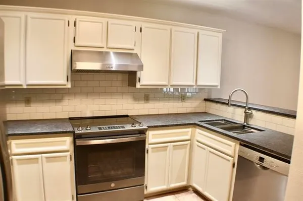 a kitchen with granite countertop white cabinets and white appliances