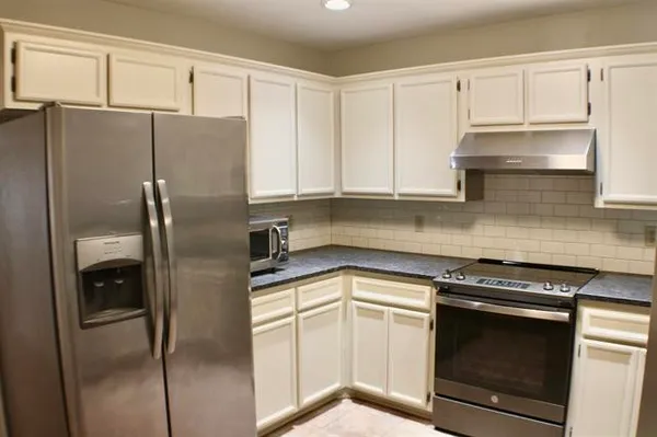 a kitchen with a refrigerator sink and cabinets