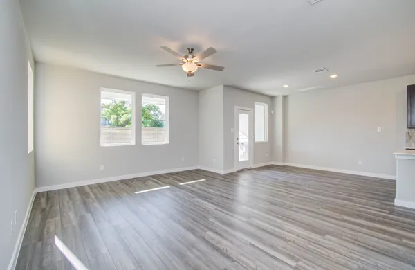 a view of an empty room with a window and wooden floor