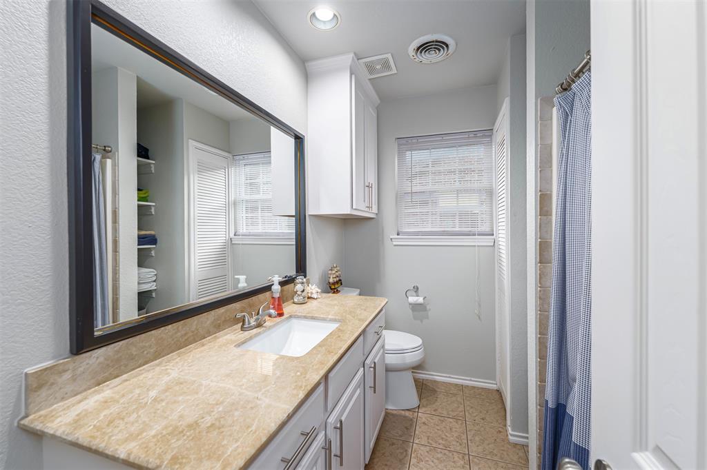 6512 Greenway Road Fort Worth, TX 76116 - Photo 21 of 38 Full bath featuring vanity, a shower with shower curtain, light tile patterned flooring, plenty of natural light, and a textured wall