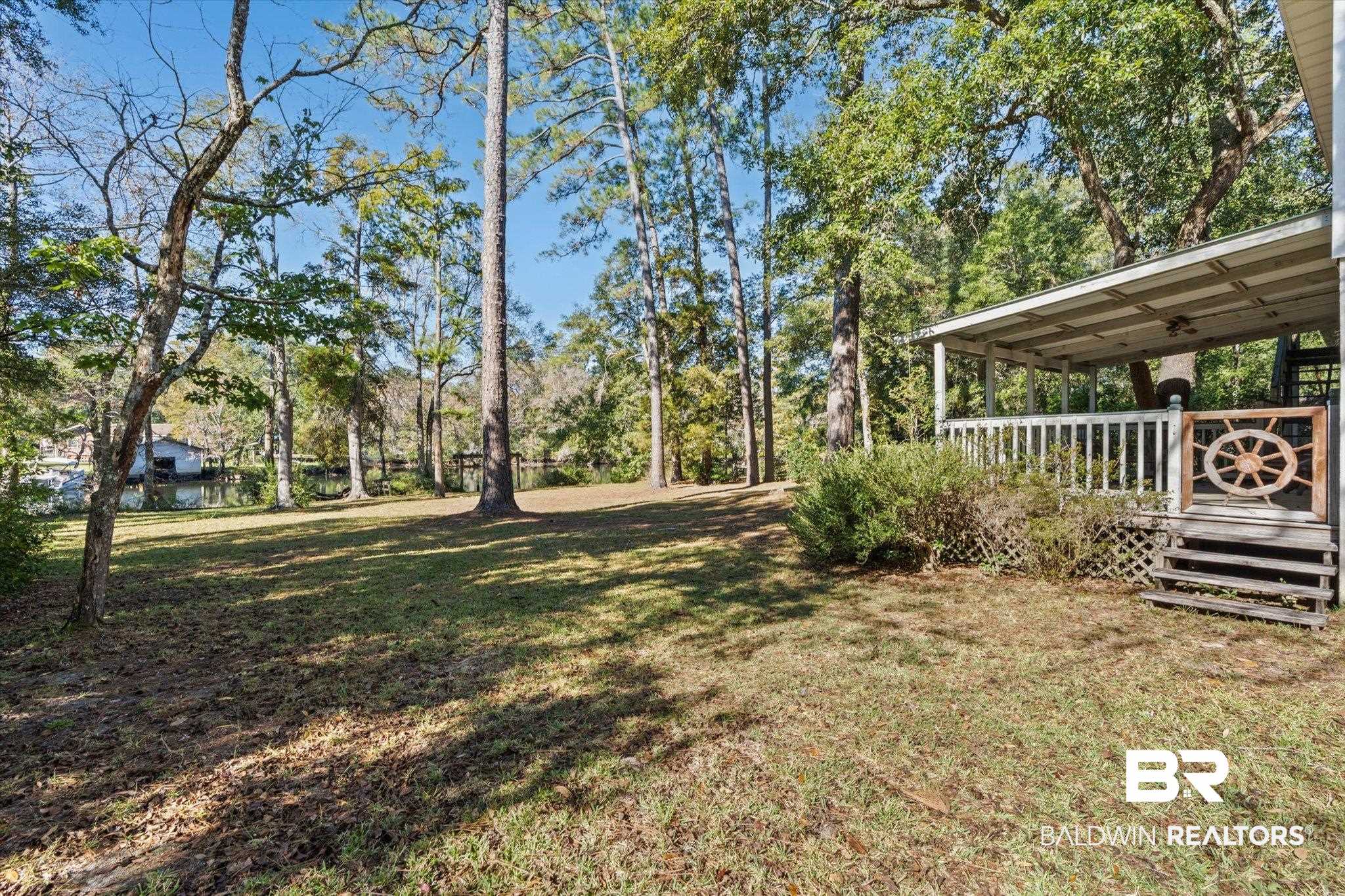 431 Simms Drive Saraland, AL 36571 - Photo 16 of 34 View of green lawn featuring view of wooded area and a wooden deck