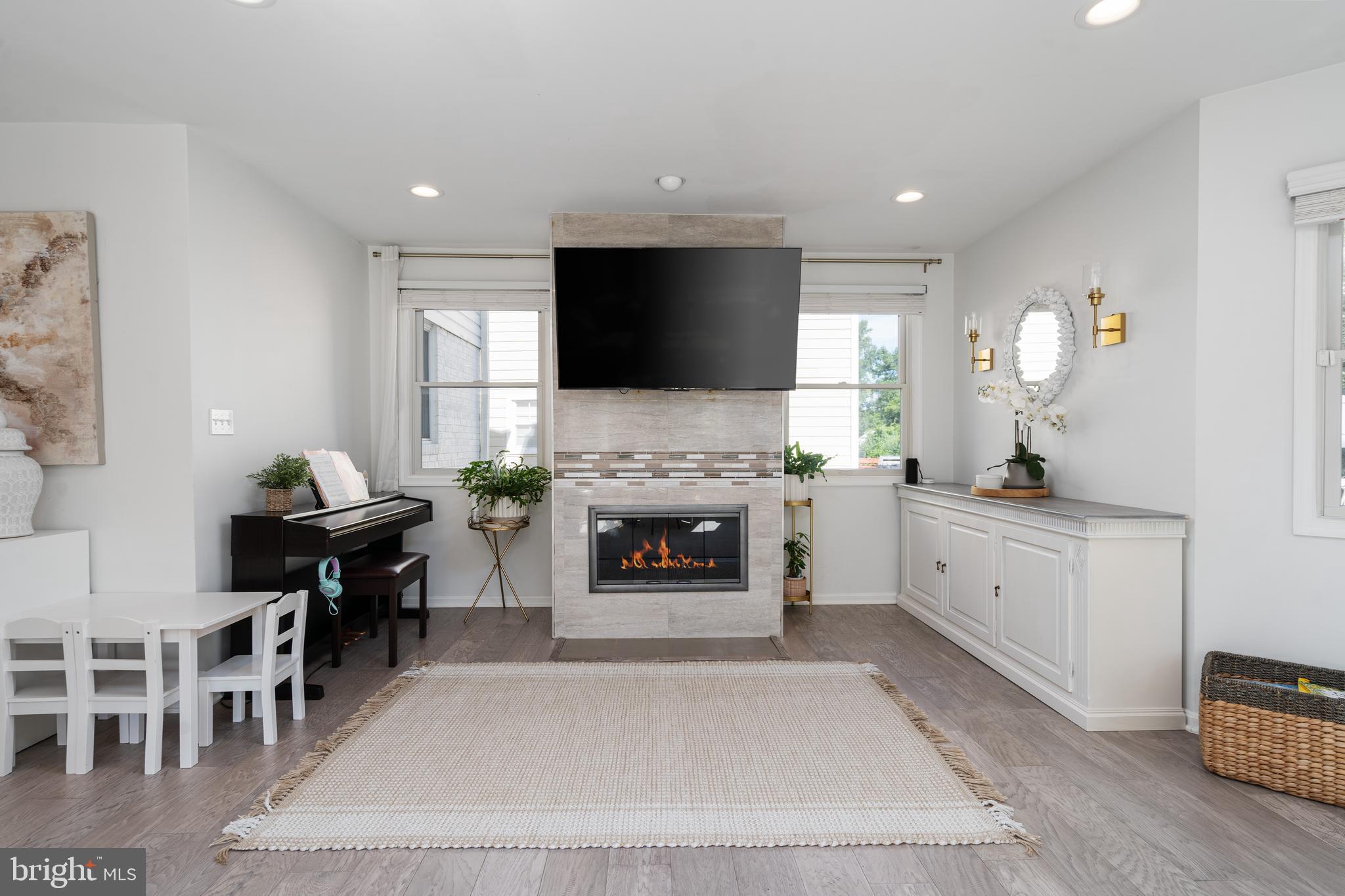 6401 Winnepeg Road Bethesda, MD 20817 - Photo 10 of 41 a living room with furniture a fireplace and a flat screen tv