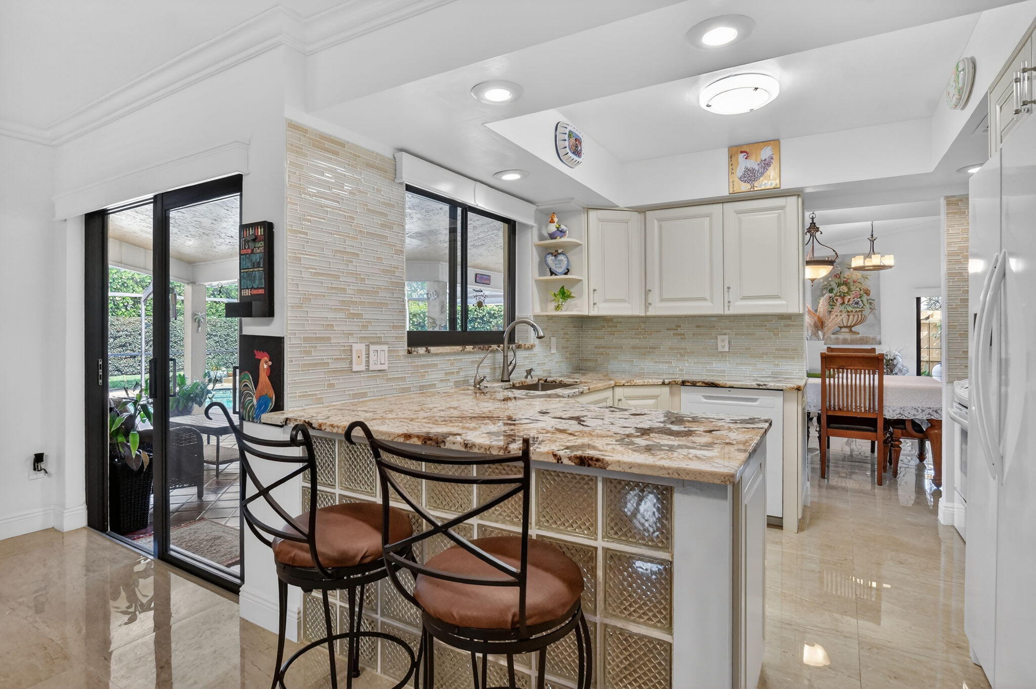 4205 Birchwood Drive Boca Raton, FL 33487 - Photo 21 of 75 a kitchen with stainless steel appliances granite countertop table chairs sink and cabinets