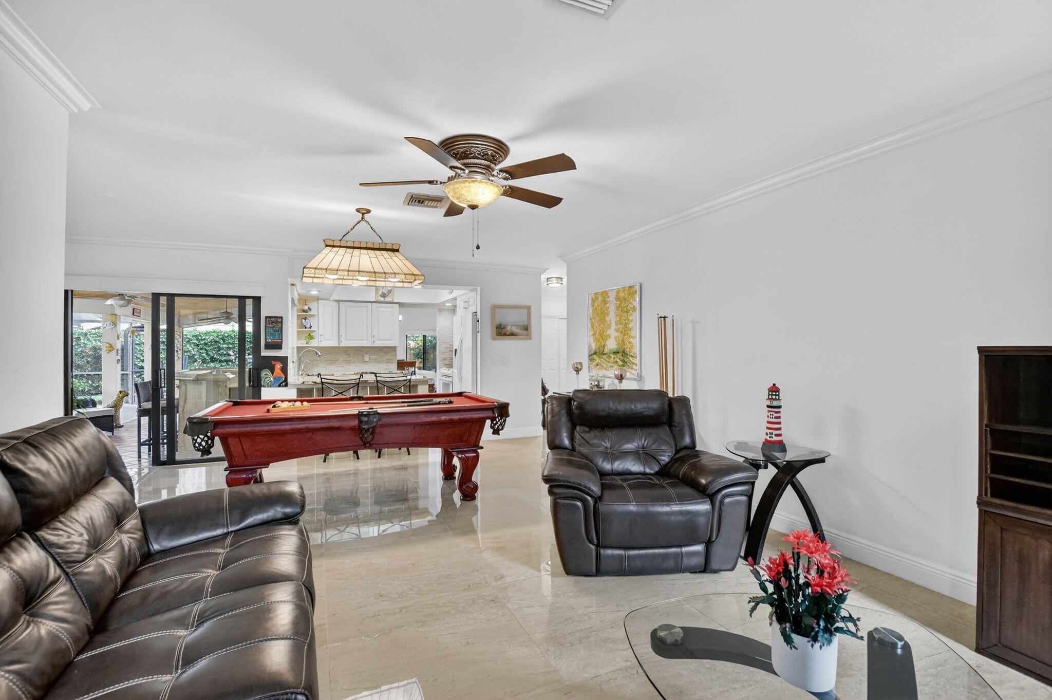 4205 Birchwood Drive Boca Raton, FL 33487 - Photo 32 of 75 a living room with furniture a chandelier and a flat screen tv