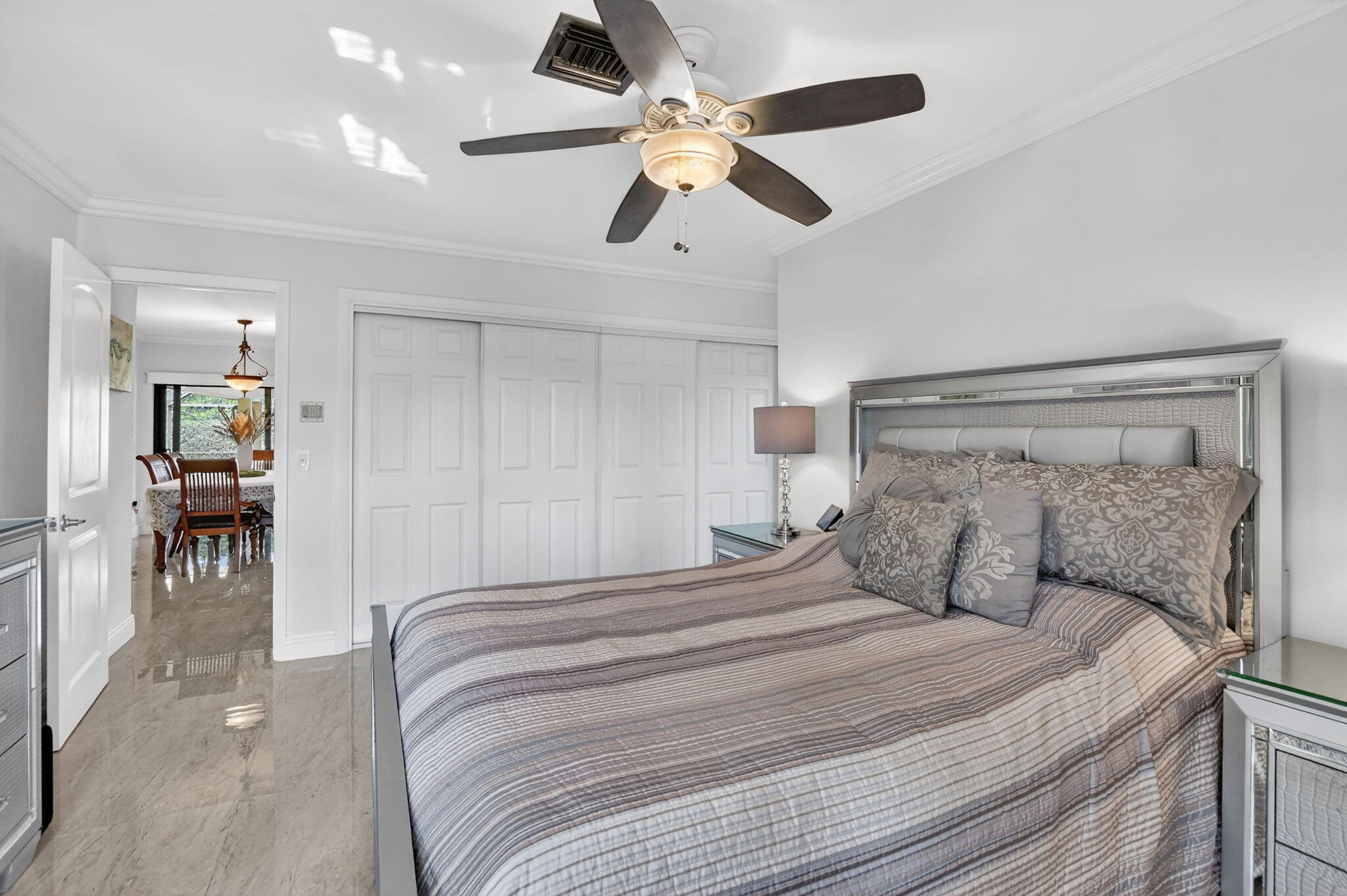4205 Birchwood Drive Boca Raton, FL 33487 - Photo 35 of 75 a bedroom with a large bed and a chandelier