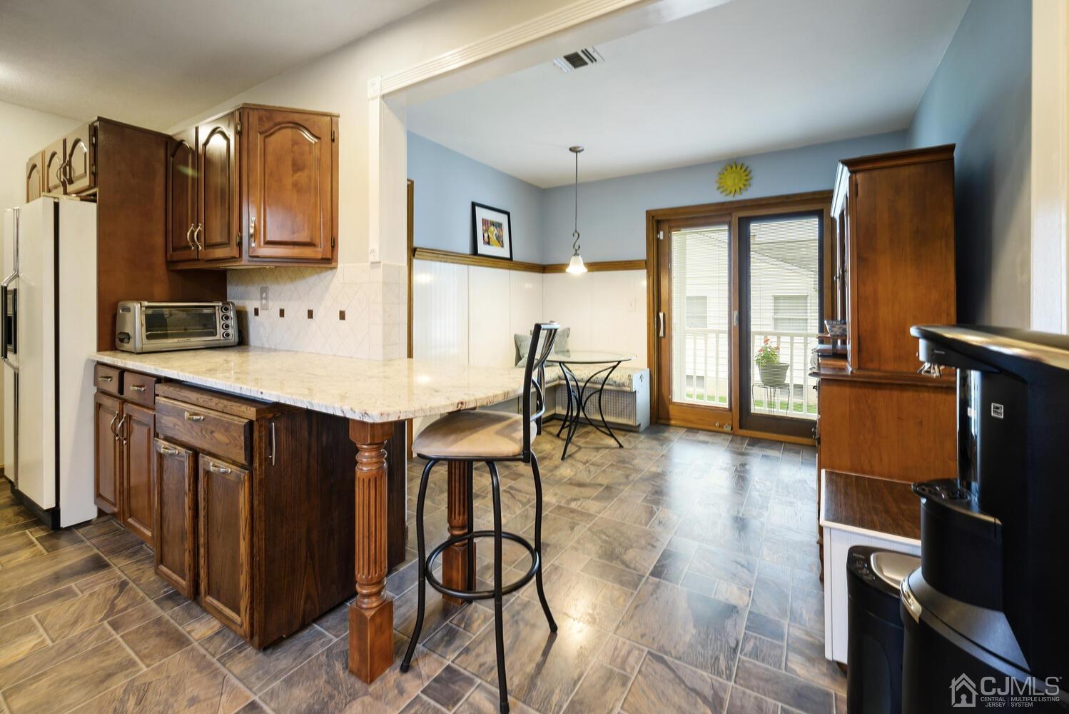 28 Rector Avenue Woodbridge, NJ 07095 - Photo 11 of 32 a living room with stainless steel appliances kitchen island granite countertop a table chairs and a refrigerator