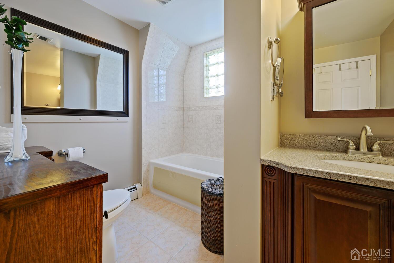 28 Rector Avenue Woodbridge, NJ 07095 - Photo 28 of 32 a bathroom with a granite countertop sink mirror and a bathtub