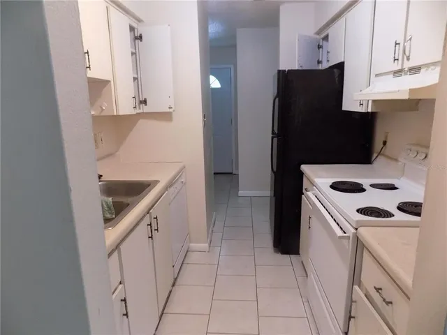 a kitchen with a refrigerator sink and cabinets