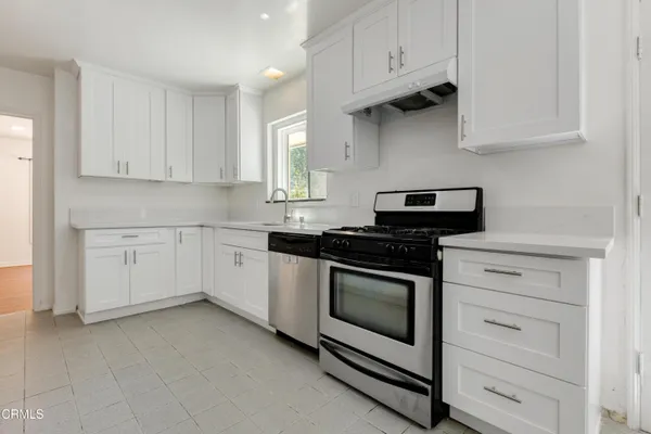 a kitchen with granite countertop white cabinets and appliances