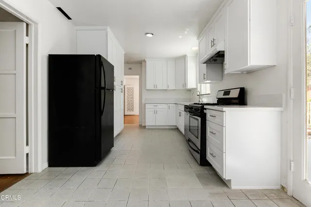 a kitchen with stainless steel appliances a refrigerator sink and cabinets