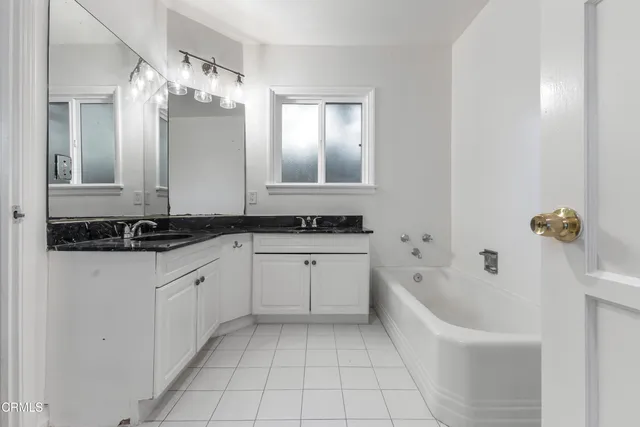 a bathroom with a bathtub sink and mirror