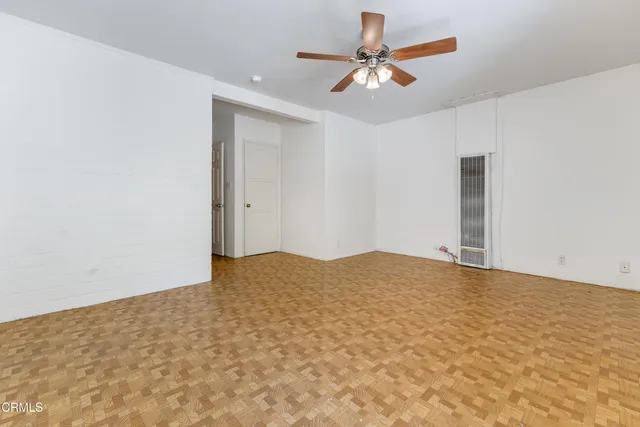 a view of empty room with wooden floor