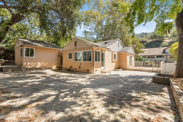 a view of a yard in front of a house with large tree