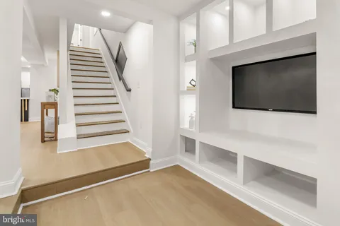 a view of a livingroom with wooden floor and staircase