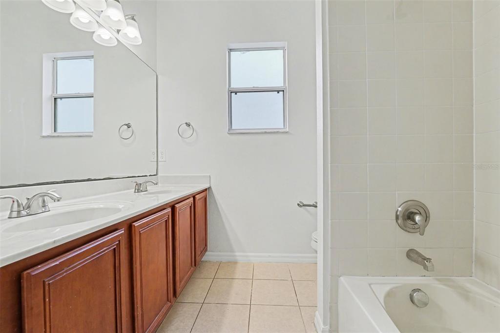 320 Snook Way Kissimmee, FL 34759 - Photo 11 of 15 a bathroom with a tub a sink and mirror