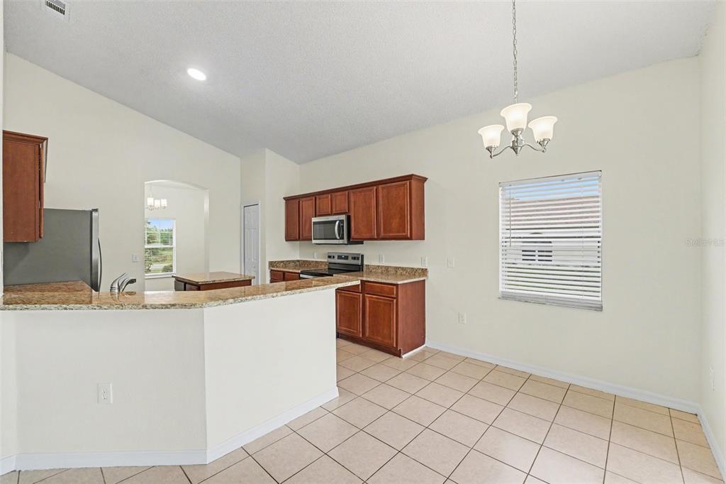 320 Snook Way Kissimmee, FL 34759 - Photo 3 of 15 a kitchen with stainless steel appliances granite countertop a sink and a refrigerator