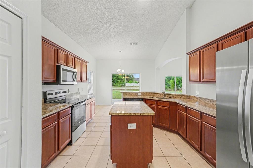 320 Snook Way Kissimmee, FL 34759 - Photo 4 of 15 a kitchen with stainless steel appliances granite countertop a sink stove and refrigerator