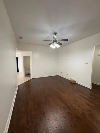 a view of a livingroom with wooden floor and a window