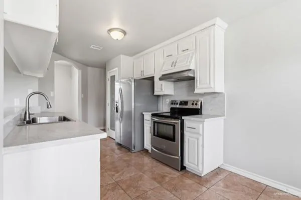 a kitchen with stainless steel appliances granite countertop a refrigerator and a sink