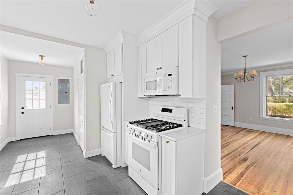 92 Hampton Circle Hull, MA 02045 - Photo 13 of 28 a kitchen with white cabinets and white appliances