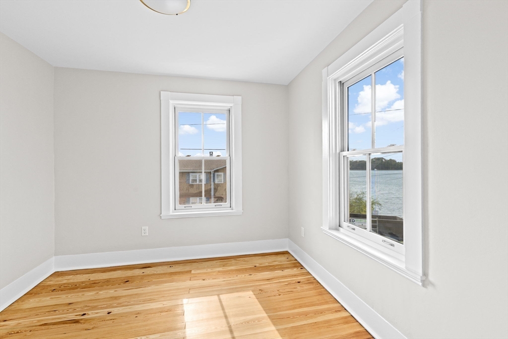 92 Hampton Circle Hull, MA 02045 - Photo 21 of 28 a view of an empty room with wooden floor and a window