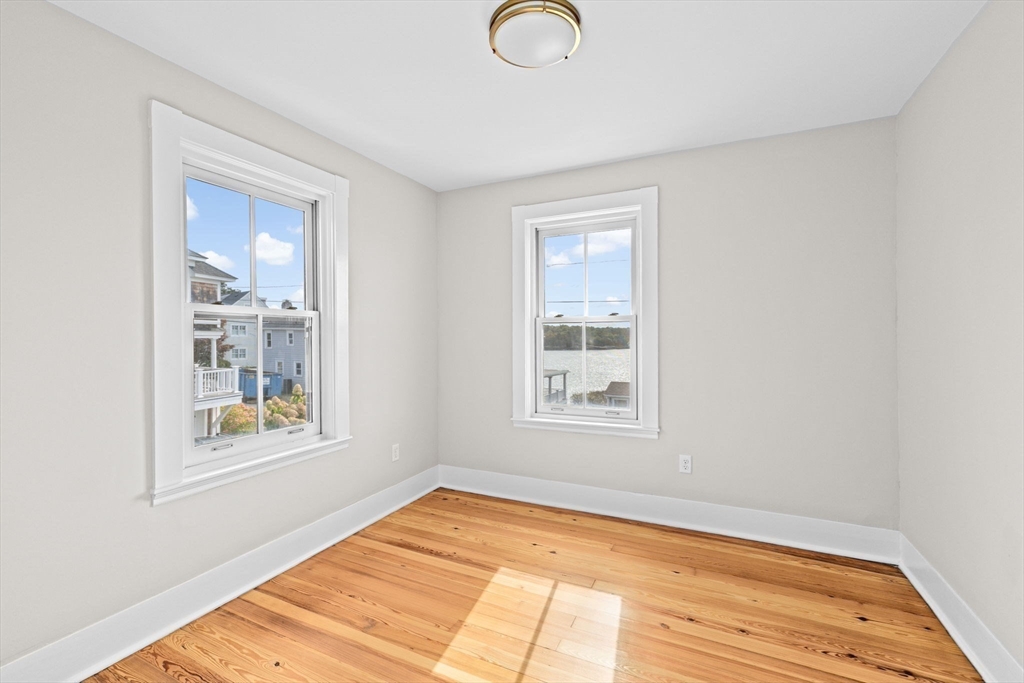 92 Hampton Circle Hull, MA 02045 - Photo 25 of 28 a view of an empty room with wooden floor and a window