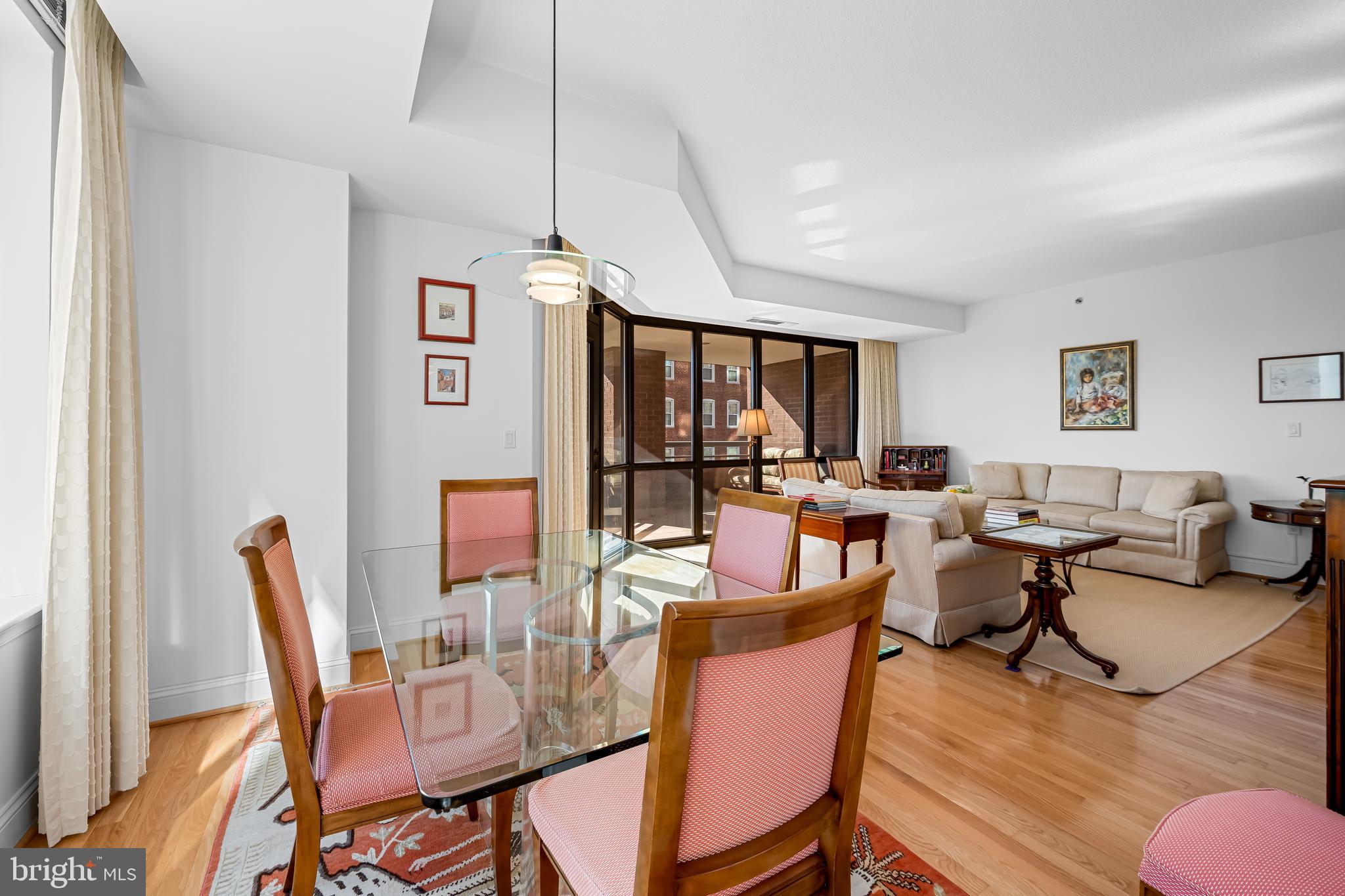 3704 North Charles Street, Unit 406 Baltimore, MD 21218 - Photo 19 of 65 a living room with furniture a dining table and a floor to ceiling window