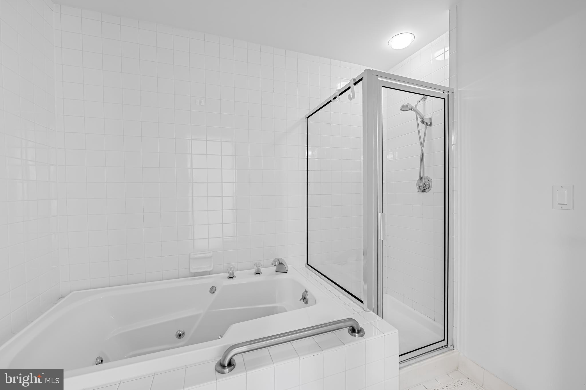 3704 North Charles Street, Unit 406 Baltimore, MD 21218 - Photo 25 of 65 a bathroom with a tub and a shower