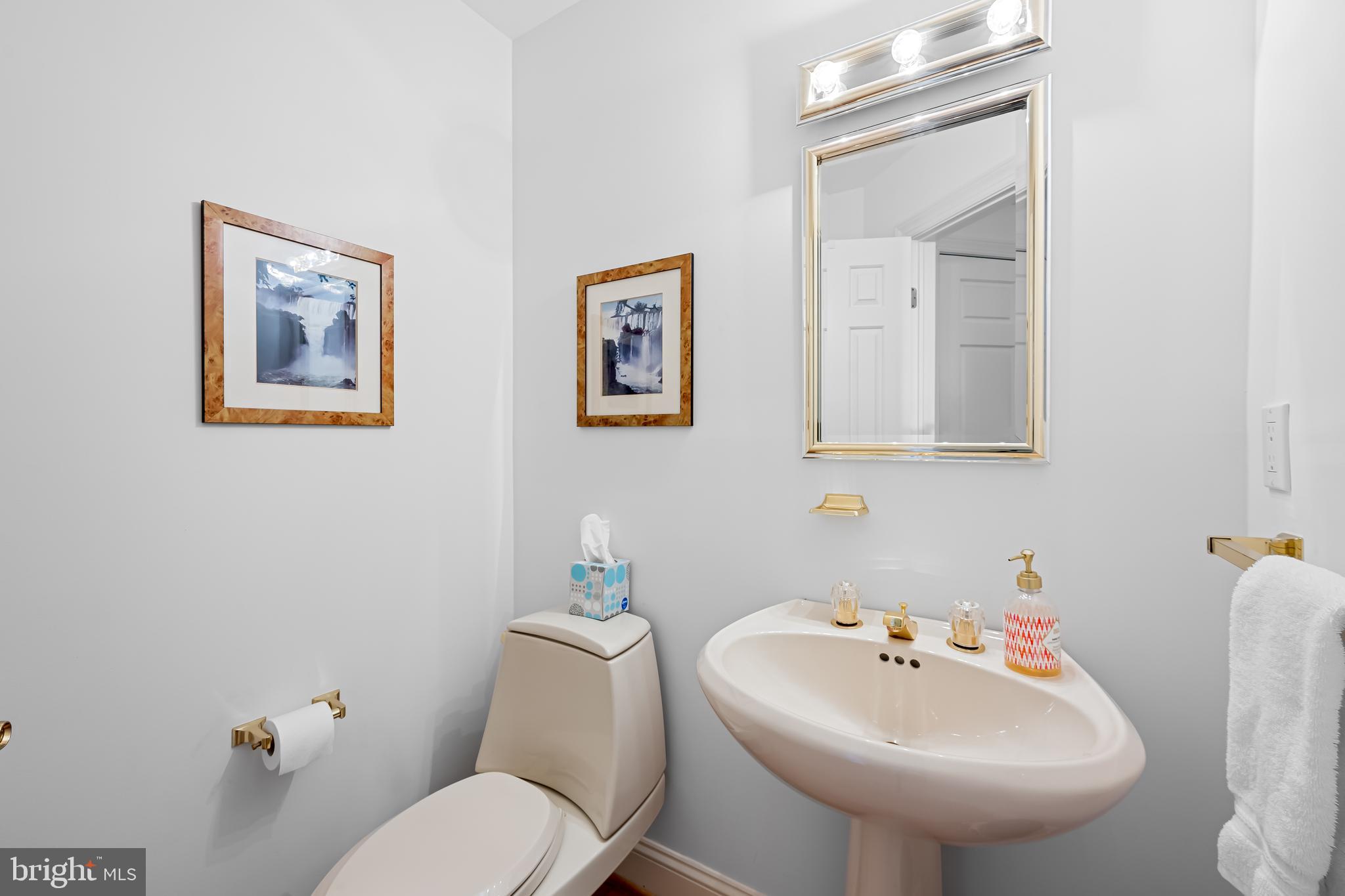 3704 North Charles Street, Unit 406 Baltimore, MD 21218 - Photo 10 of 65 a bathroom with a toilet sink and mirror