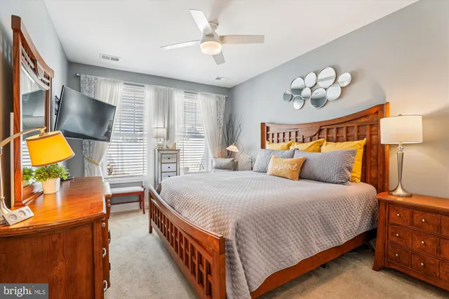 a bedroom with a bed and a flat tv screen on dresser