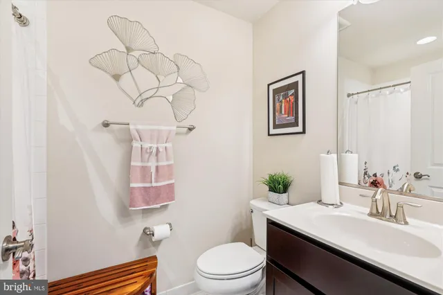 a bathroom with a sink mirror vanity and toilet