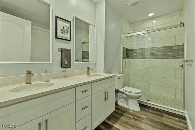a bathroom with a double vanity sink toilet and shower