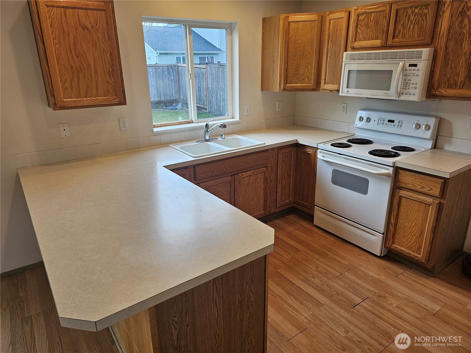 9814 Greenleaf Loop Southeast Yelm, WA 98597 - Photo 12 of 33 a kitchen with stainless steel appliances a sink a stove a microwave a sink and cabinets