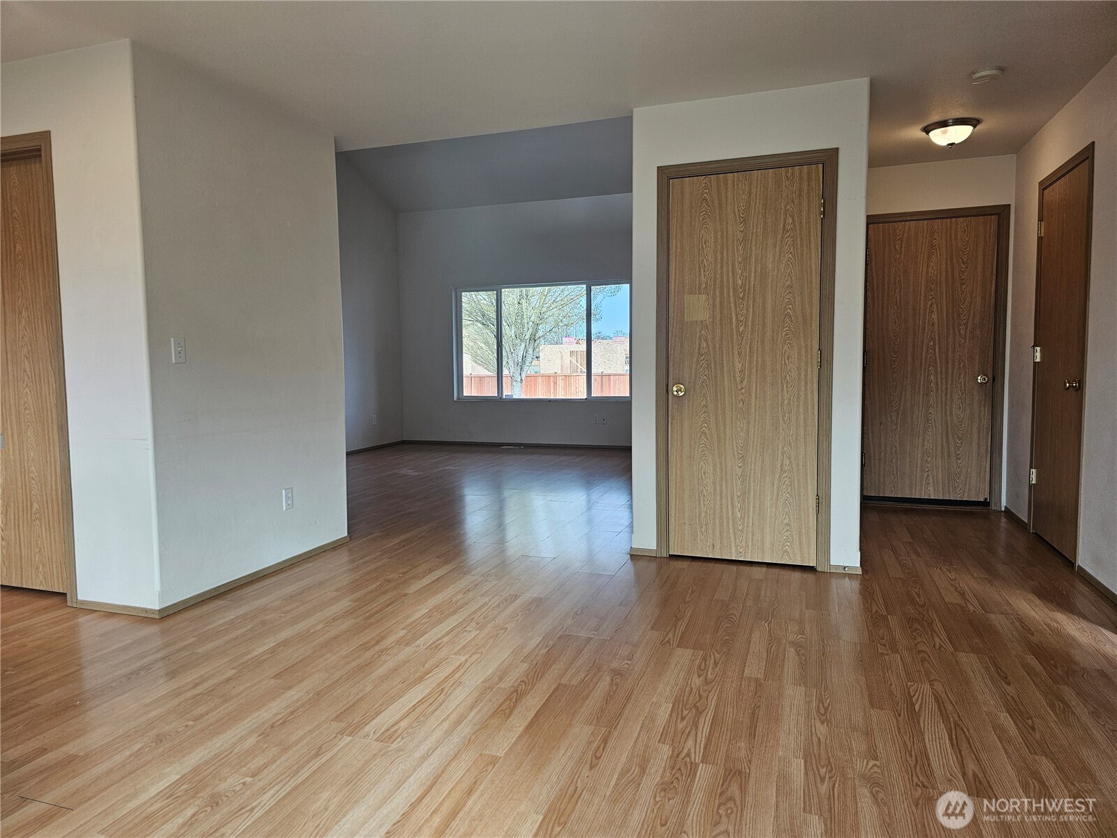 9814 Greenleaf Loop Southeast Yelm, WA 98597 - Photo 9 of 33 an empty room with wooden floor and windows