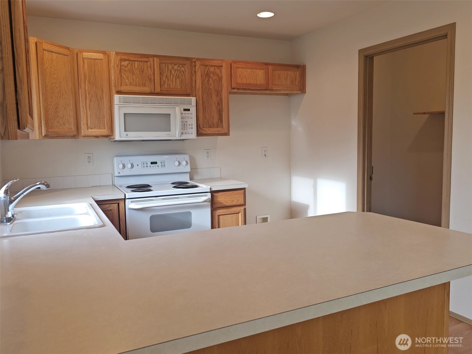 9814 Greenleaf Loop Southeast Yelm, WA 98597 - Photo 10 of 33 a kitchen with kitchen island a sink a stove and a refrigerator