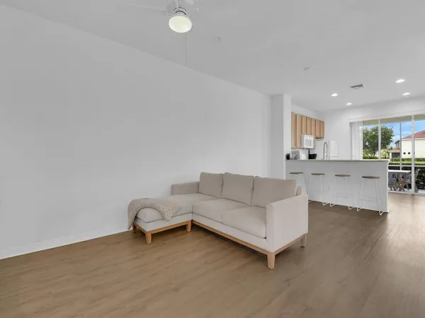 a living room with furniture and kitchen view