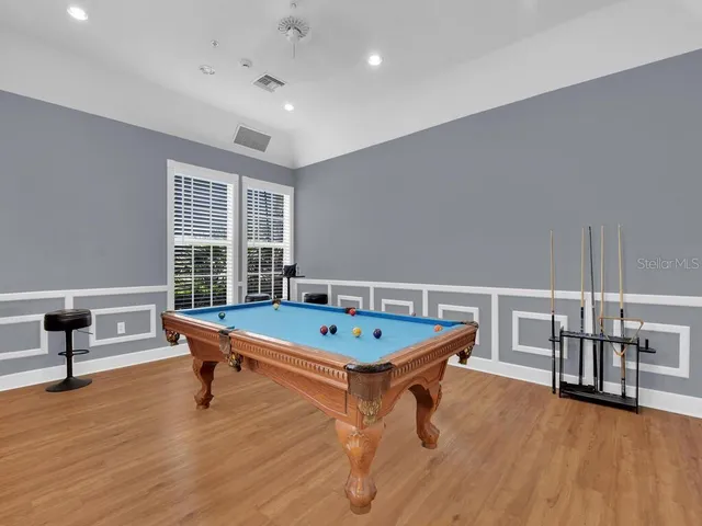 a room with furniture pool table and wooden floor