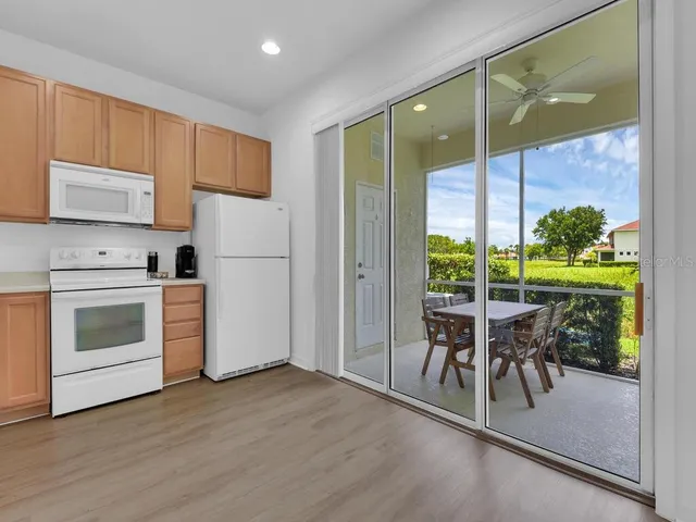a kitchen with a stove a refrigerator and furniture wooden floor