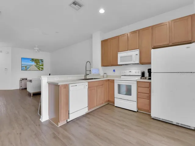 a kitchen with white cabinets and white appliances